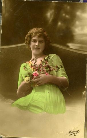 Woman in a green dress holding flowers