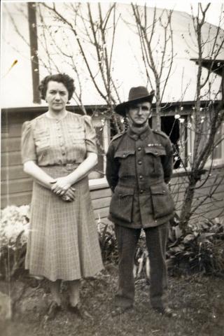 Sepia photograph of a man in woman, the man in uniform.