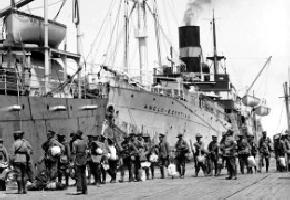 Black and white photograph of soldiers boarding a ship.