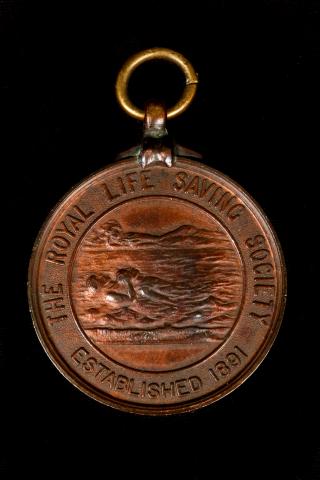 Image depicts bronze medallion with the inscription 'The Royal Life Saving Society established 1891'
