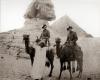 Image depicts Chamberlain on a camel with sphinx and pyramids as backdrop.